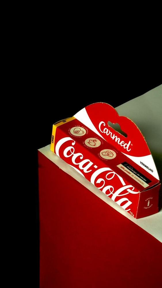 Caja del bálsamo Carmed con luz lateral sobre fondo negro y rojo